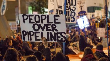 Protesters against the Dakota Access Pipeline and Keystone XL Pipeline hold a sit-in in the street next to the San Francisco Federal Building. (Source: Wikimedia Commons)